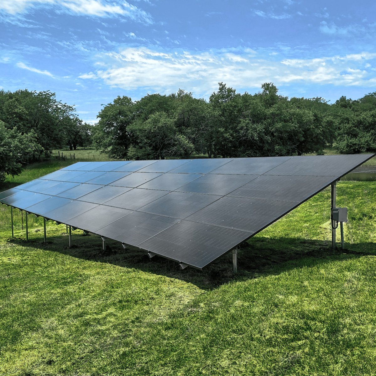 Ground-mounted solar panel system installed on a green field by Shinnova
