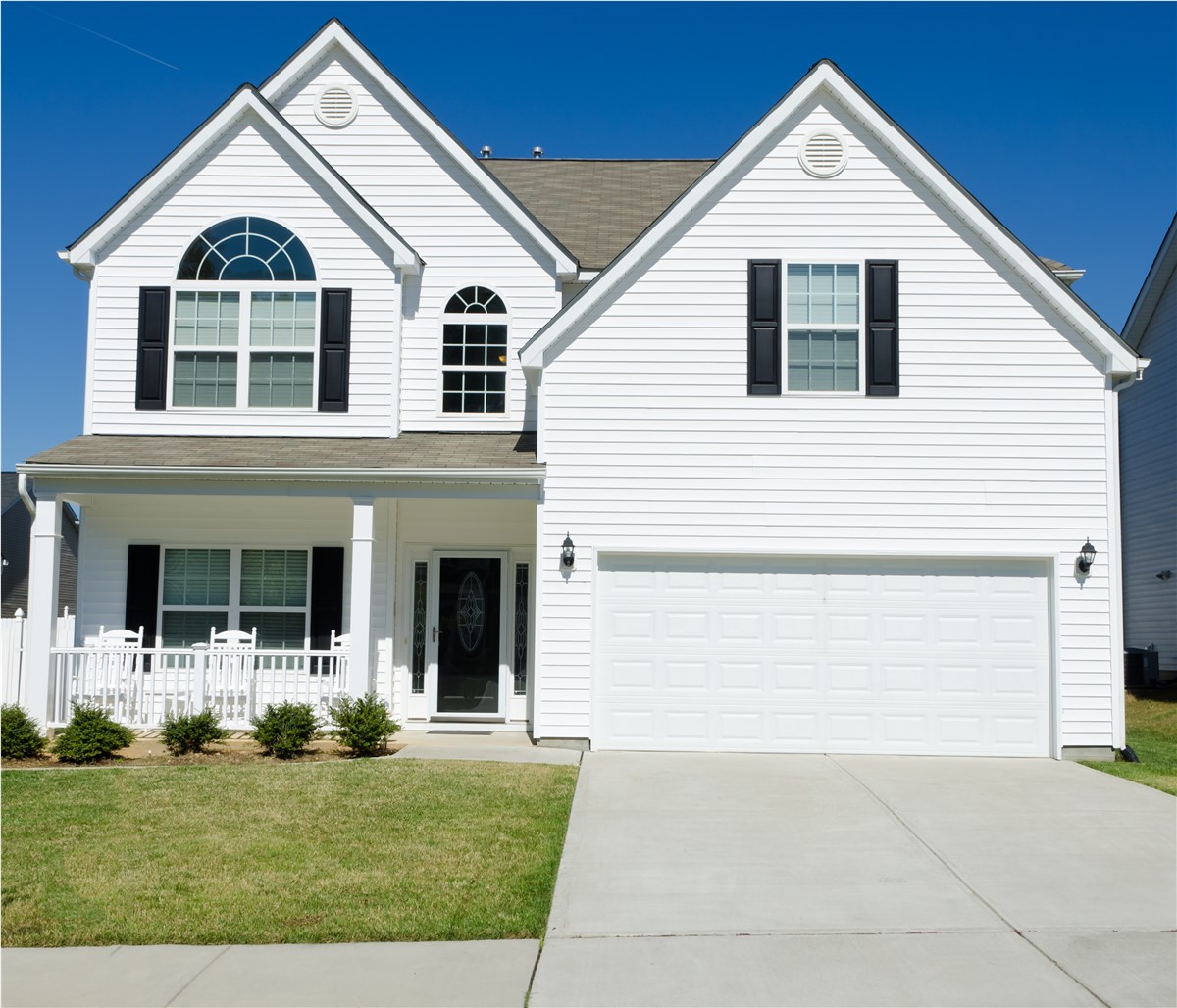Home featuring Shinnova-installed white siding with black shutters and garage