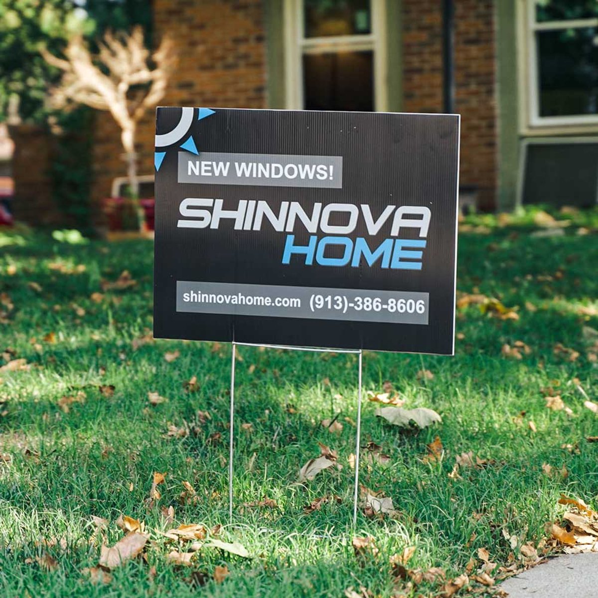 Shinnova yard sign promoting new window installations on green lawn